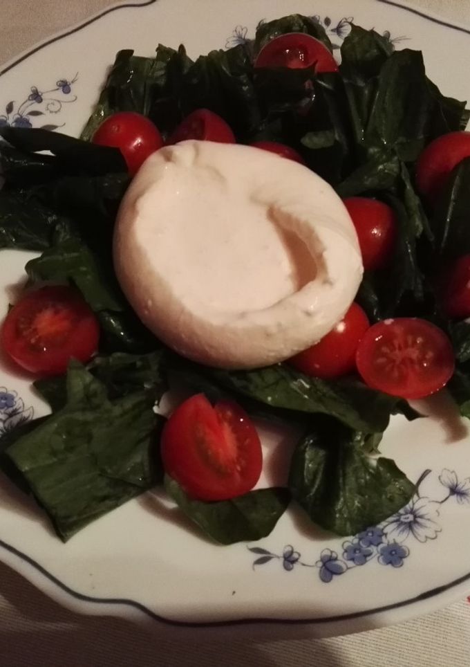 Una foto de Ensalada de espinacas con burrata