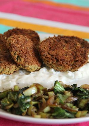 A picture of Oven baked felafel over Tzatziki-like sauce.