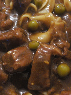A picture of Beef and noodles with peas.