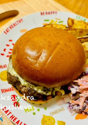 A picture of Cheddar cheeseburger with potatoes and salad.
