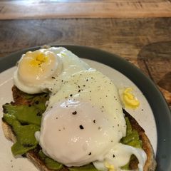 A picture of Poached egg and smashed avocado on toast.