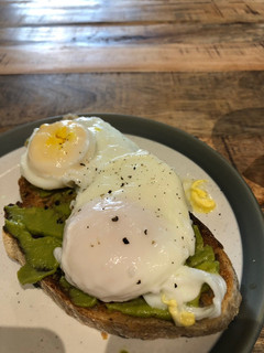 A picture of Poached egg and smashed avocado on toast.