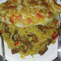 A picture of Noodles with meat and fried egg.