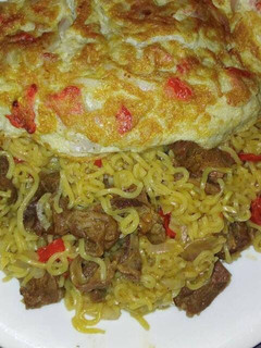 A picture of Noodles with meat and fried egg.