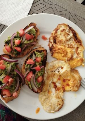 Una foto de Tapas de aguacate y huevos volteados