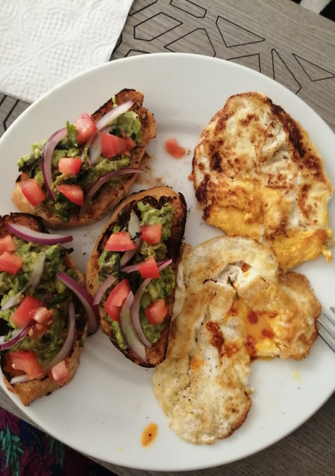 Una foto de Tapas de aguacate y huevos volteados