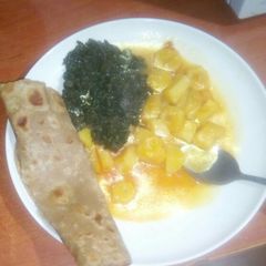 A picture of Brown chapati spinach and potatoes.