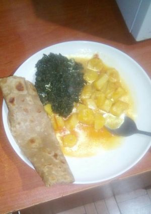 A picture of Brown chapati spinach and potatoes.