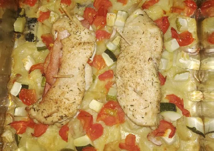 Pechugas de pollo rellenas sobre patatas panaderas y verduras