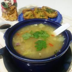A picture of Chicken soup with garlic bread.