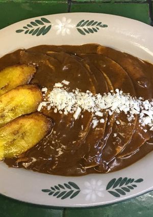 A picture of Mole Enchiladas with Plantain.