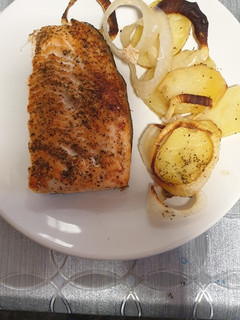 Una foto de Salmón al horno con cama de patatas y cebolla