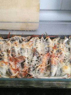 Una foto de Boquerones al horno con patatas panaderas, cebolla y queso fundido