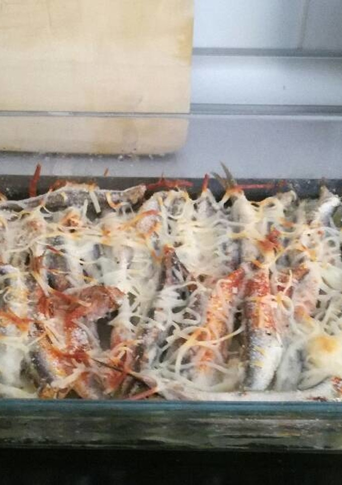 Una foto de Boquerones al horno con patatas panaderas, cebolla y queso fundido