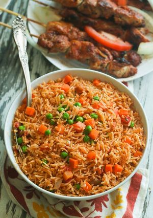 A picture of Garnished Jellof  Rice and pepper chicken meat.