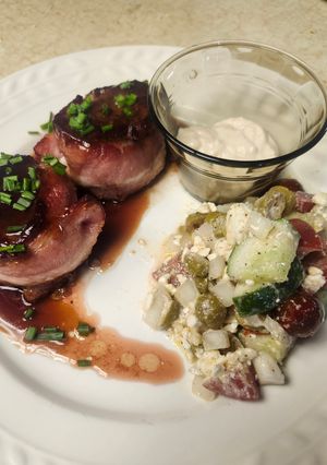 A picture of Brad's bacon wrapped venison loin chops with port wine au jus and cucumber salad.