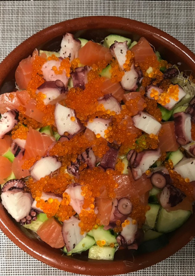 Una foto de Chirashi - sushi cubierto con mariscos