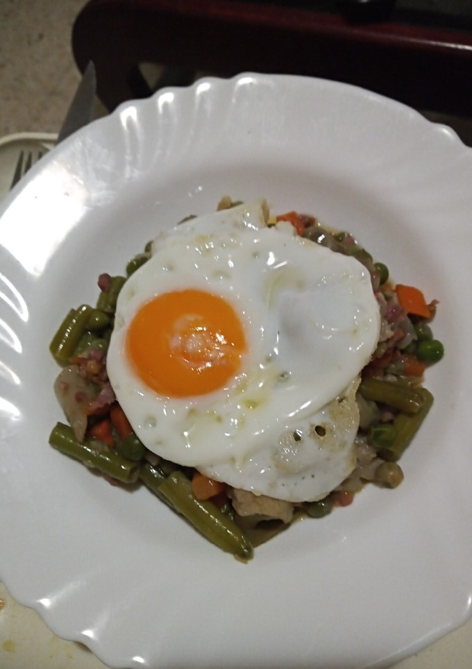 Una foto de Huevo frito sobre menestra de verduras