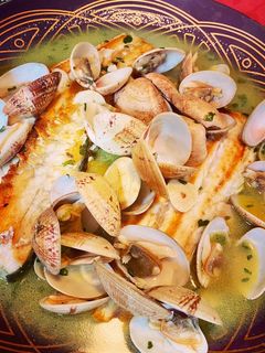 Una foto de Lubina con almejas en salsa verde