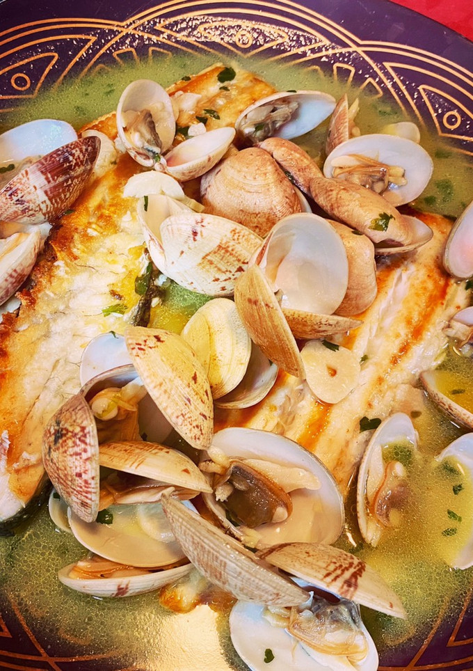Una foto de Lubina con almejas en salsa verde