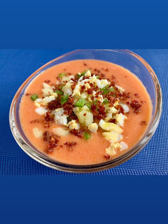 Una foto de Crema de gazpacho asalmorejado con guarnición de verduras, jamón y huevo