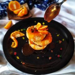 A picture of Fluffy orange pancake with sweet and sour orange sauce.