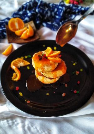 A picture of Fluffy orange pancake with sweet and sour orange sauce.
