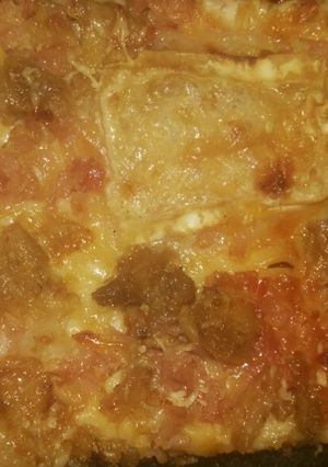 Una foto de Pizza de atún, jamón york, queso rulo de cabra, bacon y cebolla