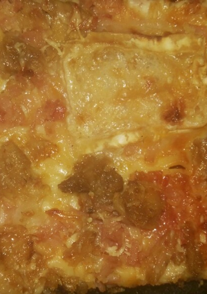 Una foto de Pizza de atún, jamón york, queso rulo de cabra, bacon y cebolla