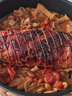 Una foto de Redondo de pavo relleno de pimiento, piñones, orejones y ciruela en salsa