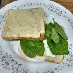 Una foto de Sándwich de hummus, espinacas y pavo