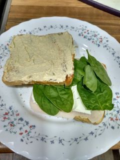 Una foto de Sándwich de hummus, espinacas y pavo