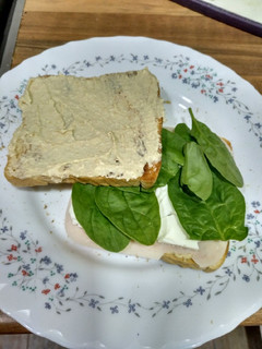 Una foto de Sándwich de hummus, espinacas y pavo