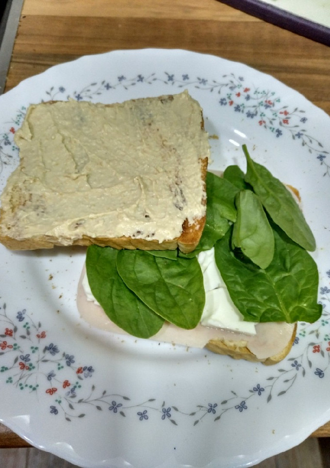 Una foto de Sándwich de hummus, espinacas y pavo