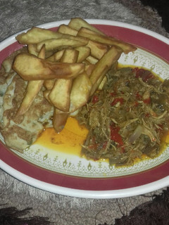 A picture of Fried sweet potatoes wit fried egg n chicken sauce.