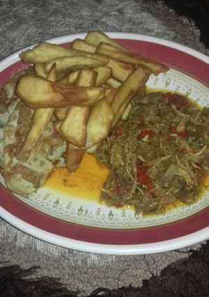 A picture of Fried sweet potatoes wit fried egg n chicken sauce.