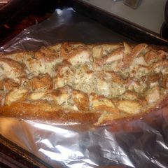 A picture of Chicken Alfredo in a garlic parm & herb bread bowl.