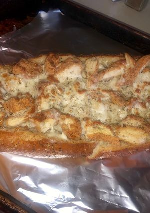 A picture of Chicken Alfredo in a garlic parm & herb bread bowl.