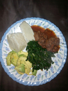 A picture of Ugali with wet fry beef n mixed greens/guacamole.