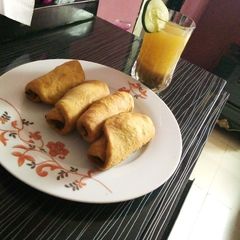 A picture of Fish rolls and tamarind drink.