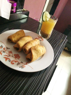A picture of Fish rolls and tamarind drink.