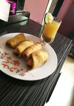 A picture of Fish rolls and tamarind drink.