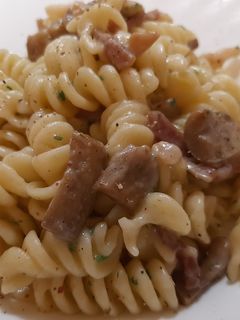 O poză a rețetei Fusilli cu ciuperci, speck și ceapă verde.
