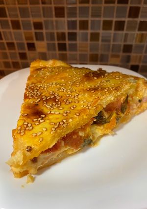 Una foto de Torta de jamón, provolone, tomate y albahaca