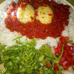 A picture of Rice and stew with eggs and salad.