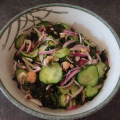 A picture of Salad with smoked salmon, wakame,cucumber and red onion.