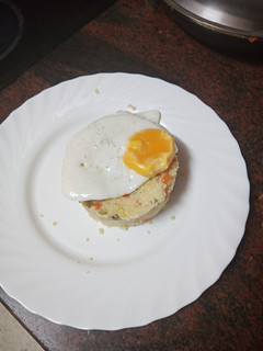 Una foto de Huevo frito sobre salteado de cuscús y verdura