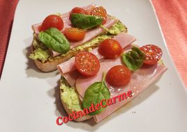 Tostas con crema de aguacate y queso, jamón york y cherries