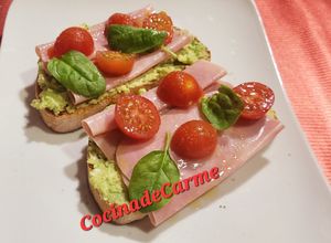 Una foto de Tostas con crema de aguacate y queso, jamón york y cherries