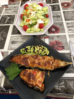 Una foto de Berenjenas rellenas con guarnición de aguacate y ensalada